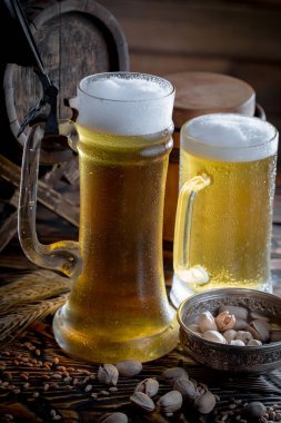 Masadaki bardakta hafif bira kompozisyonu ve eski bir arka planda aksesuar.