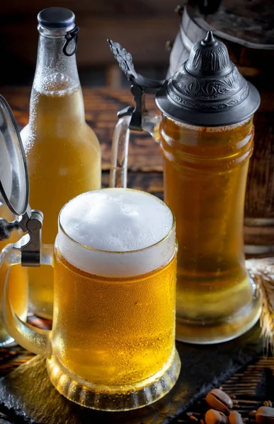 在桌子上的杯子里放着淡淡的啤酒 在旧的背景上有配饰 — 图库照片