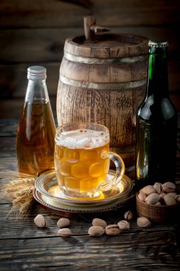 Masadaki bardakta hafif bira kompozisyonu ve eski bir arka planda aksesuar.