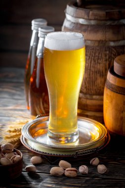 Masadaki bardakta hafif bira kompozisyonu ve eski bir arka planda aksesuar.