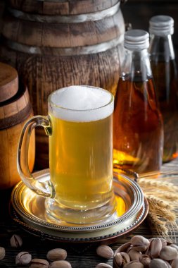 Masadaki bardakta hafif bira kompozisyonu ve eski bir arka planda aksesuar.