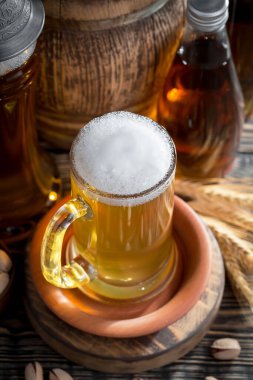 Masadaki bardakta hafif bira kompozisyonu ve eski bir arka planda aksesuar.