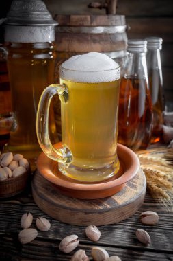 Masadaki bardakta hafif bira kompozisyonu ve eski bir arka planda aksesuar.