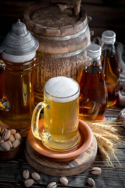 Masadaki bardakta hafif bira kompozisyonu ve eski bir arka planda aksesuar.