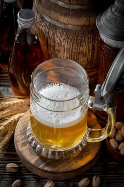 Masadaki bardakta hafif bira kompozisyonu ve eski bir arka planda aksesuar.
