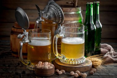 Masadaki bardakta hafif bira kompozisyonu ve eski bir arka planda aksesuar.