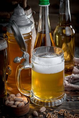 Masadaki bardakta hafif bira kompozisyonu ve eski bir arka planda aksesuar.