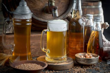 Masadaki bardakta hafif bira kompozisyonu ve eski bir arka planda aksesuar.