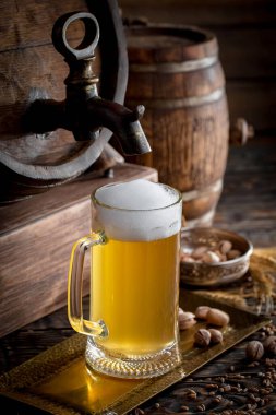 Masadaki bardakta hafif bira kompozisyonu ve eski bir arka planda aksesuar.