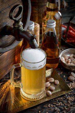 Masadaki bardakta hafif bira kompozisyonu ve eski bir arka planda aksesuar.