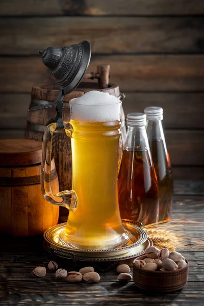 在桌子上的杯子里放着淡淡的啤酒 在旧的背景上有配饰 — 图库照片