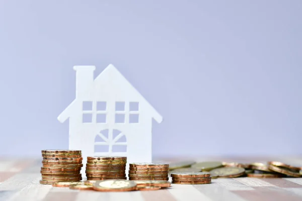 Holzhaus und Geldmünzen des Immobilieninvestitionskonzepts stapeln — Stockfoto