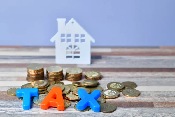 TAX word on wooden home and stack money coins concept — Stock Photo, Image