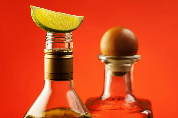 Tequila bottles and slice of lime — Stock Photo, Image