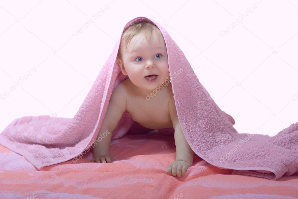Baby under pink towel