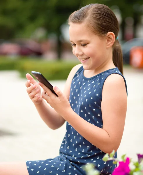 Menina está usando smartphone — Fotografia de Stock