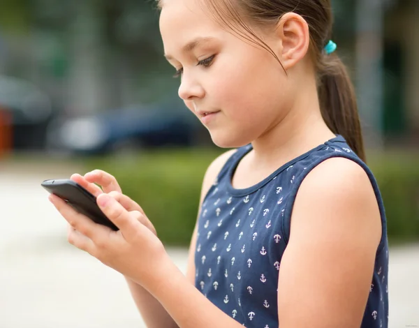 Menina está usando smartphone Fotos De Bancos De Imagens