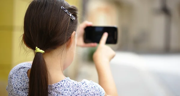 Menina está usando smartphone — Fotografia de Stock
