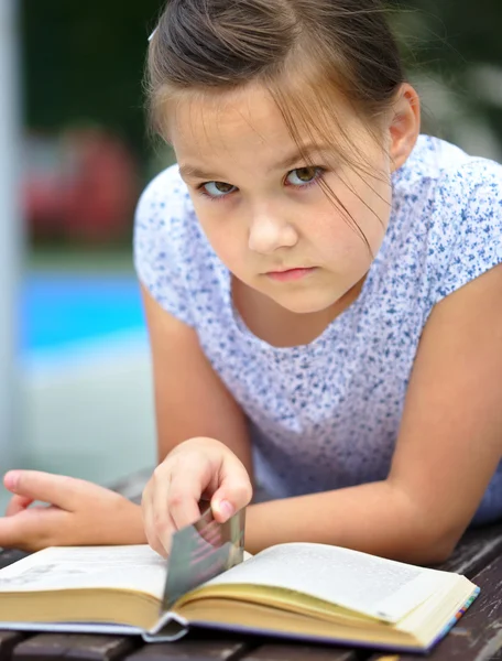 어린 소녀는 야외에서 책을 읽고는 — 스톡 사진
