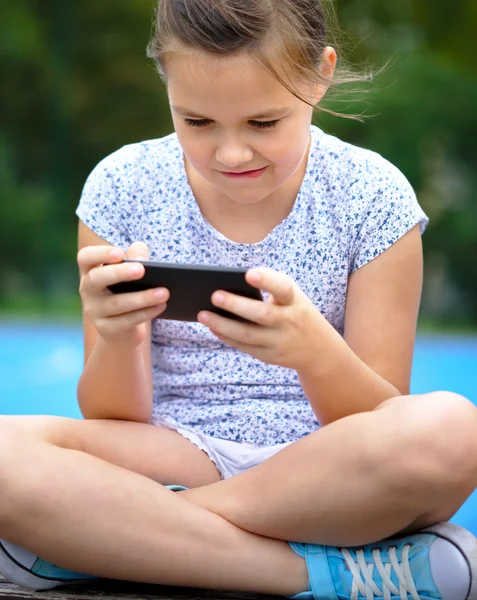 Menina está usando smartphone — Fotografia de Stock