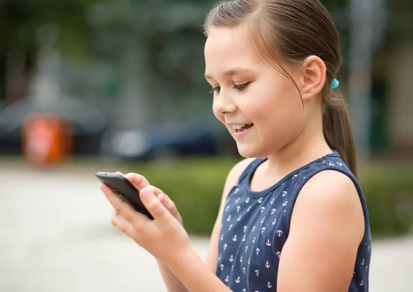 Menina está usando smartphone — Fotografia de Stock