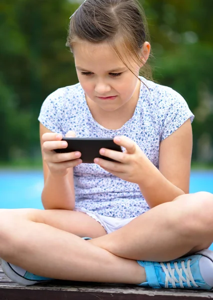 女の子は、スマート フォンを使用しています。 — ストック写真