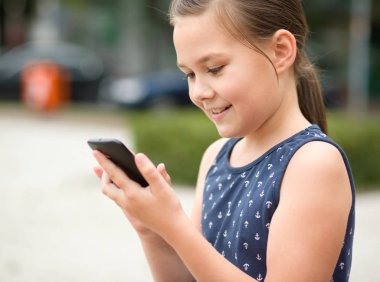 Küçük kız akıllı telefon kullanıyor.