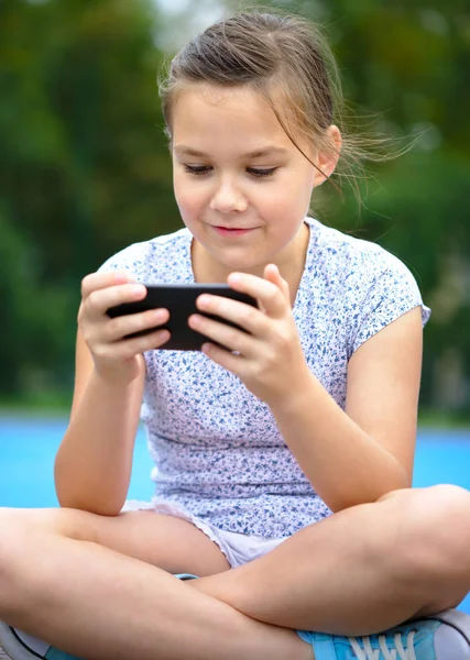 女の子は、スマート フォンを使用しています。 — ストック写真