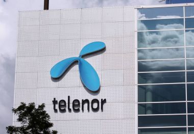 Sign with telenor logo on building. Telenor is a Norwegian multinational telecommunications company clipart