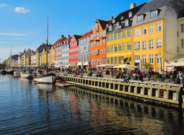 Copenhagen, Danimarka - 15 Nisan 2010: Nyhavn, ünlü ve popüler turistik hedef iskele renkli binalar ve tekne Kopenhag, Danimarka, 17. yy waterfront, kanal ve eğlence bölgesi yeme ve içme ile