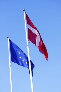 Avrupa Birliği AB ve Danimarka Danimarka bayrağı güneşli bir arka plan olarak bir mavi gökyüzü ile rüzgarda sallayarak kutup