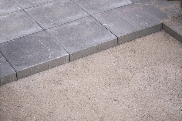 Beton kare kaldırımlar ya da fayanslar düzleştirilmiş düz kum yüzeyine güzelce yerleştirilmiş. Hala bazı işler eksik..