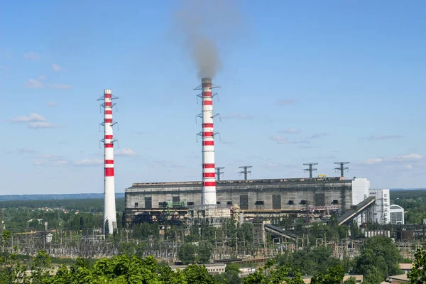 Tuyau usine industrielle avec fumée contre ciel bleu vif et au-dessus des arbres verts — Photo