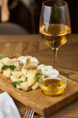 Peynir tabağı, bal ve şarap.