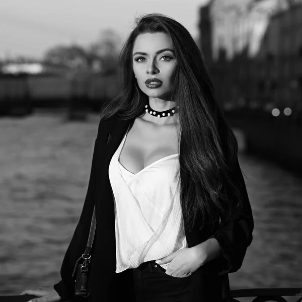 Attractive brunette woman posing against river on background — Stock Photo, Image