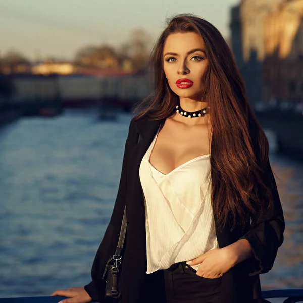 Attractive brunette woman posing against river on background — Stock Photo, Image