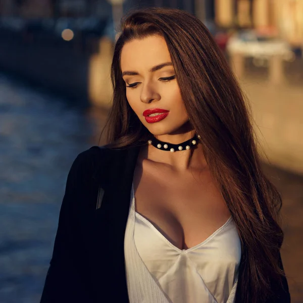 Attractive brunette woman posing against river on background — Stock Photo, Image