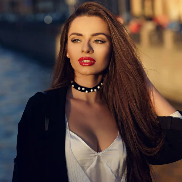 Attractive brunette woman posing against river on background — Stock Photo, Image