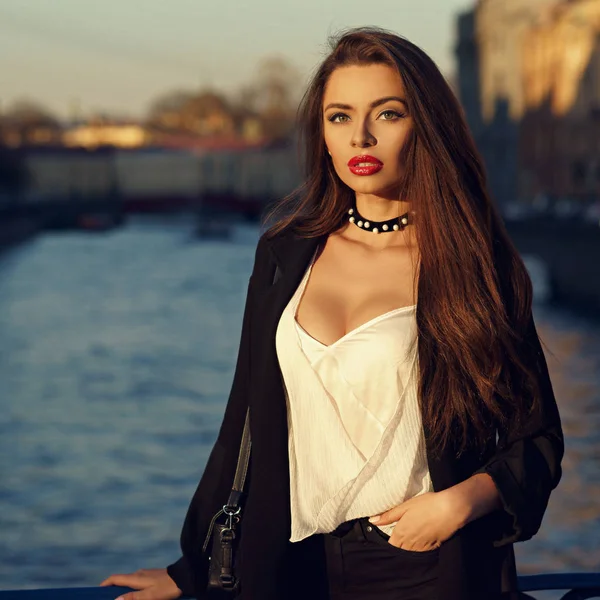 Attractive brunette woman posing against river on background Royalty Free Stock Images