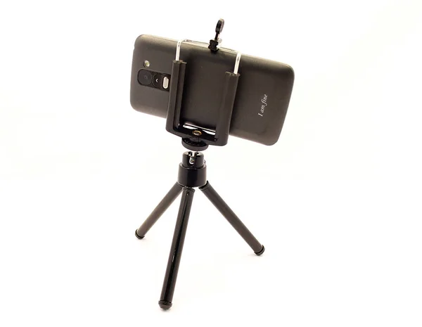Tripod ve akıllı telefon beyaz arkaplanda izole edildi.