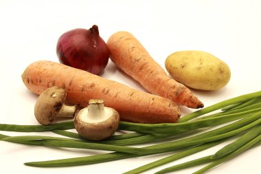 Vegetables: black and purple onions, carrots, potatoes, mushrooms, green onions. isolated on white backgroun