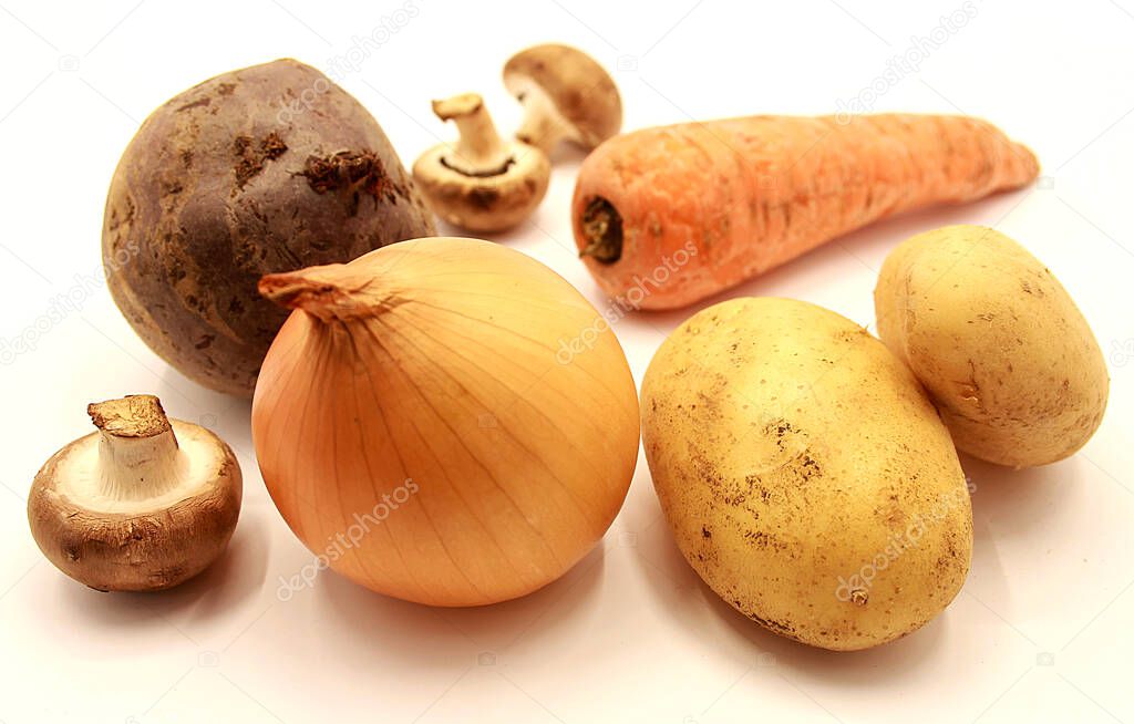 Vegetables: yellow onions, potatoes, carrots, beets and mushrooms isolated on white background