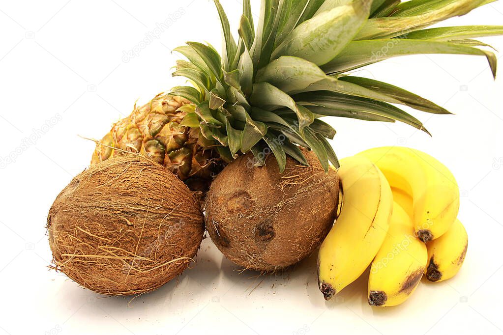 Ripe pineapple, bananas and coconuts closeup isolated on white background