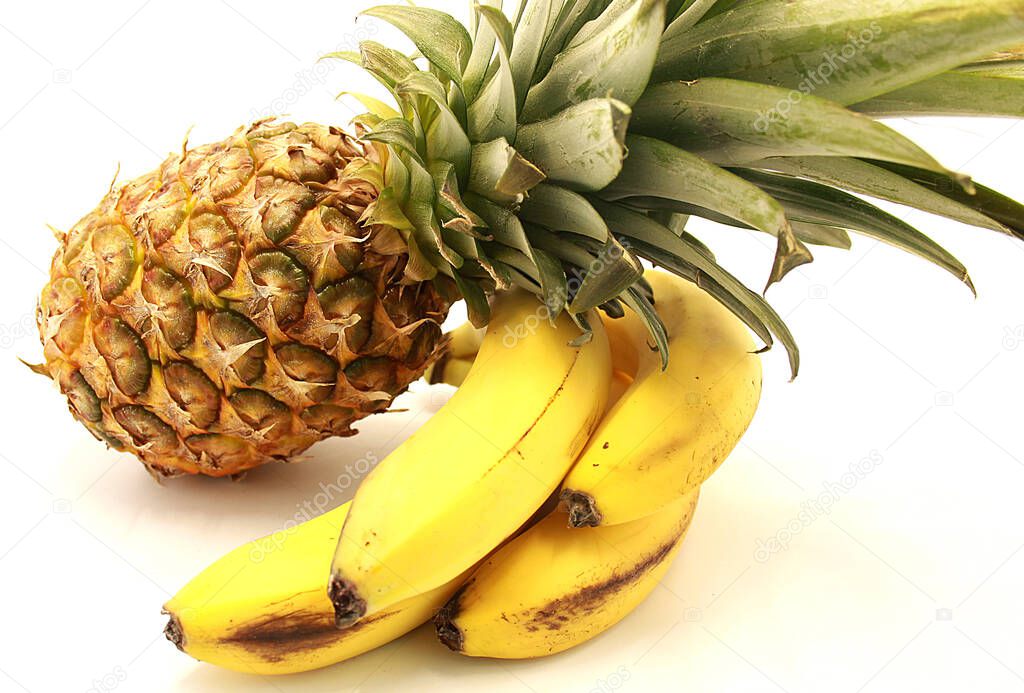 Ripe pineapple and bananas close-up isolated on a white background