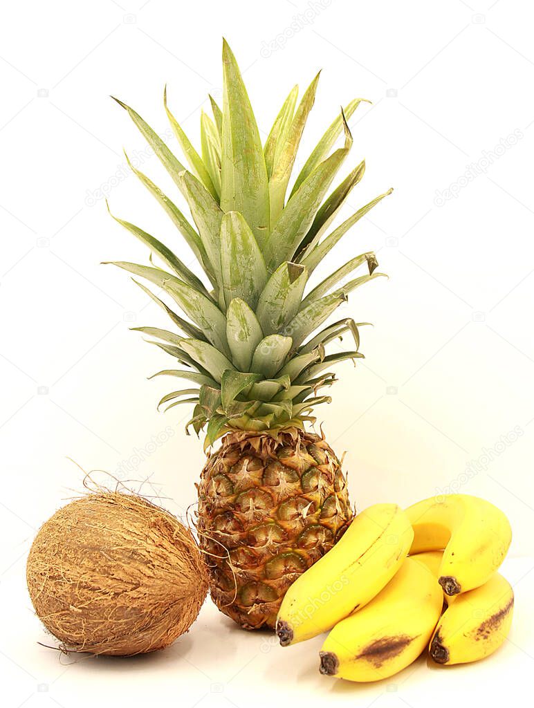 Ripe pineapple, bananas and coconut close-up isolated on a white background