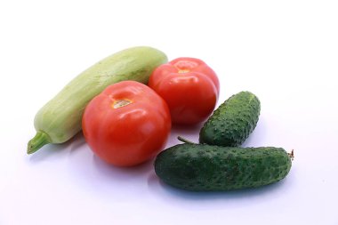 Beyaz arka planda domates, salatalık ve kabak fotoğrafı, yakın plan.