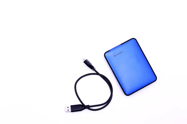 Dosyaları saklamak için bir cep sabit diskinin ve beyaz arkaplanda bir usb kablosunun fotoğrafı