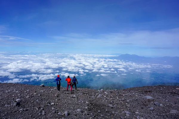 青空を背景に山頂に登るセメル登山家 — ストック写真