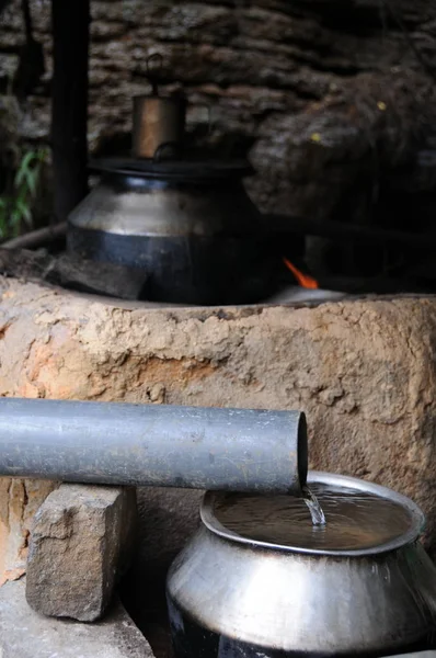 Water vanaf het voorjaar loopt rechtstreeks naar de keuken, langs de weg café. — Stockfoto