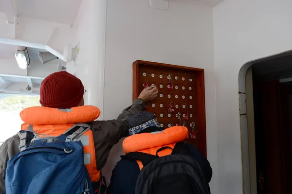 Besucher hinterlassen Schmuckstücke mit persönlichen Nummern beim Aussteigen von einem Kreuzfahrtschiff in Feuerland. — Stockfoto